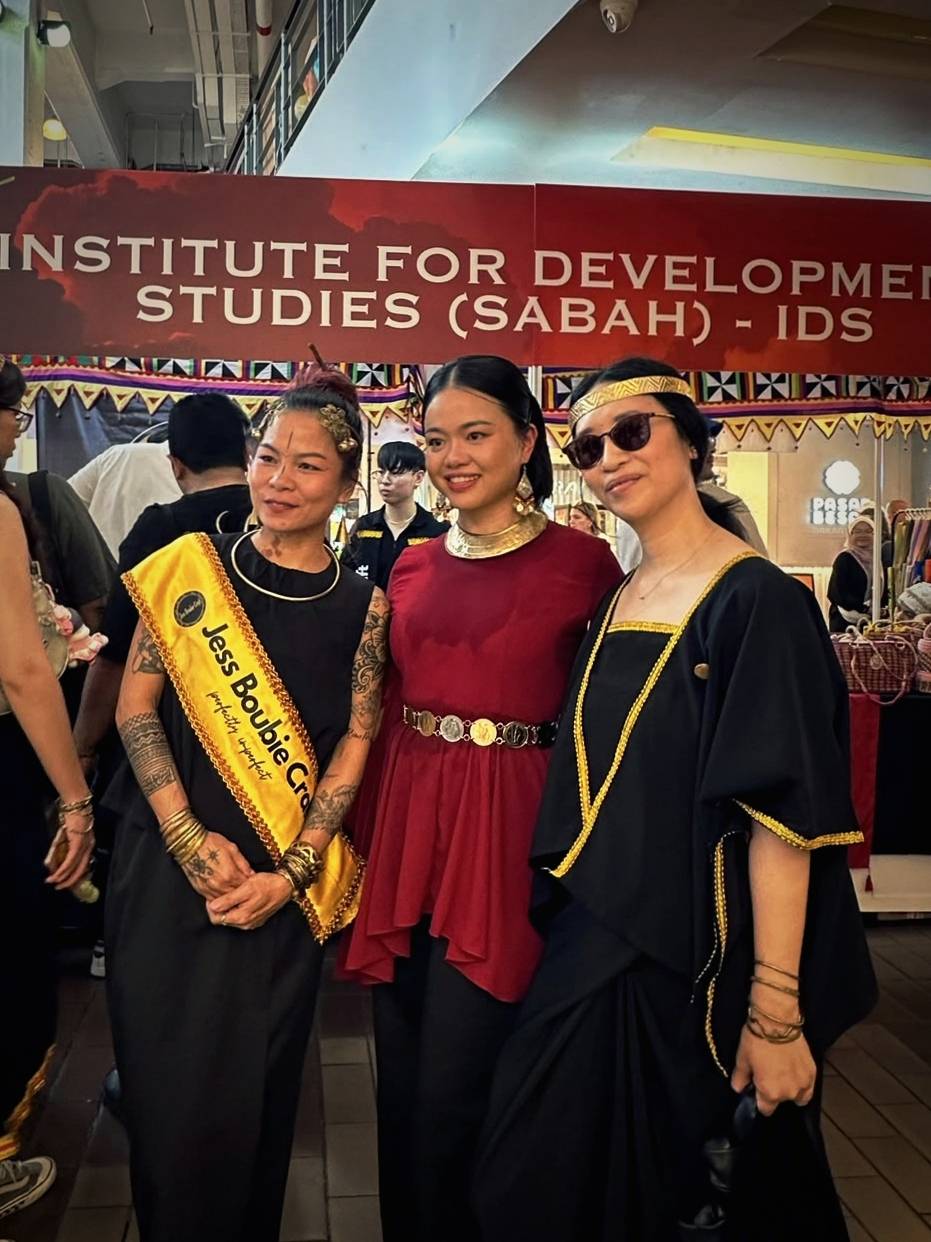 Dabra Sia wearing a brass headpiece and jewelry with Jess and a friend at an event